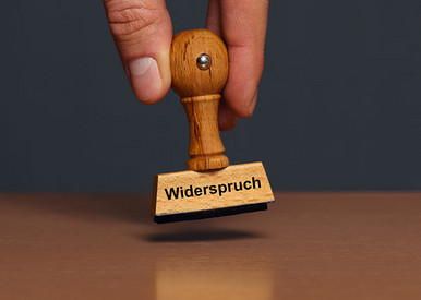 Hand hält Stempel mit Aufdruck Widerspruch