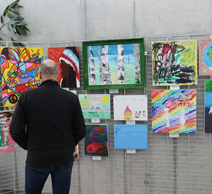 Eine Person schaut sich Bilder an einer Wand an